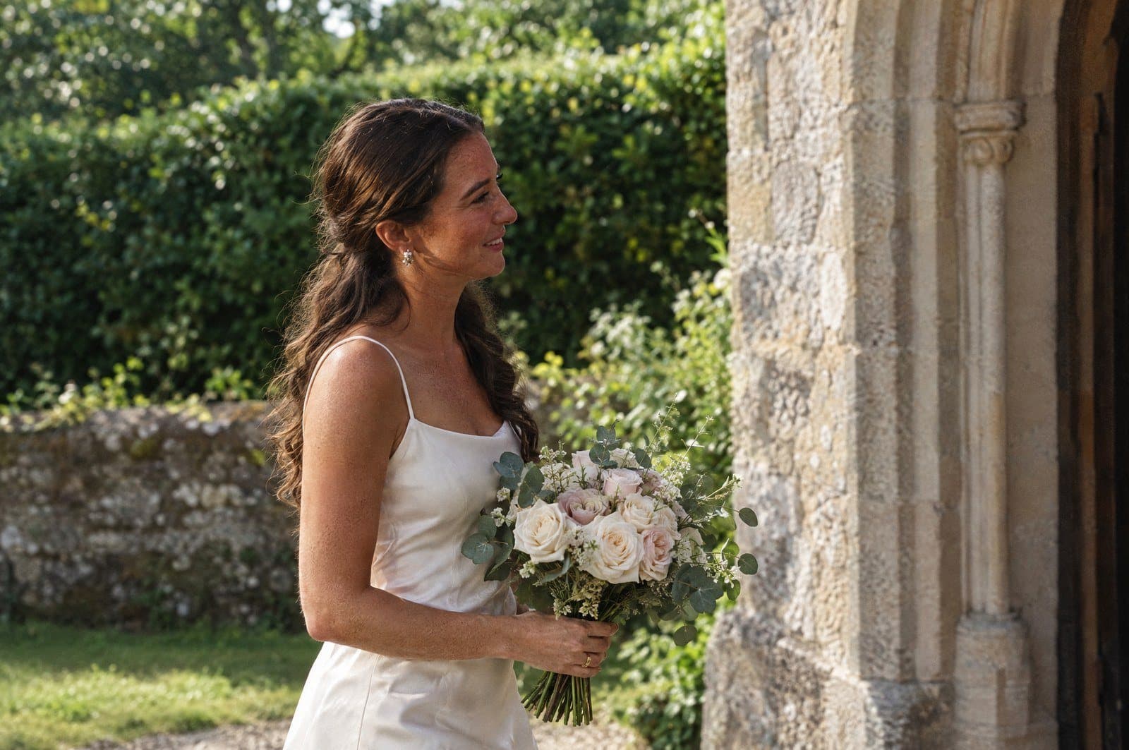 A bride with her bouquet outside the church door on her wedding day